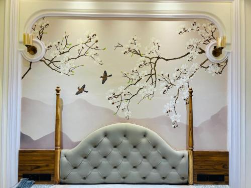 a bedroom with a bed and a tree with birds at Hotel Virasat-E-Bushahr in Rāmpur