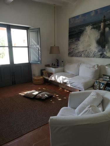 a living room with a white couch and a wave painting at La Porta Rossa in Stromboli