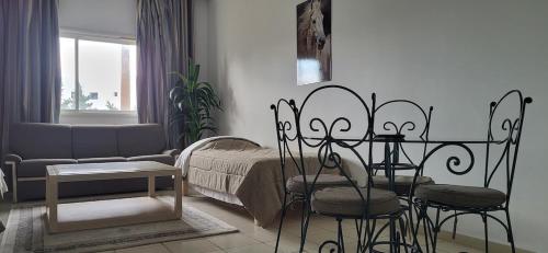 a living room with a couch and a table and chairs at Wonderful Hotel Apartment in Hammamet