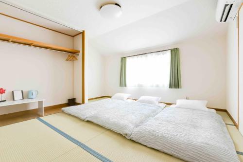 a bedroom with a large bed and a window at PLUS 9 Station INN in Izumi-Sano
