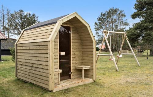 a wooden outhouse with a swing and a swing at Beautiful Home In Skjern With Kitchen in Skjern