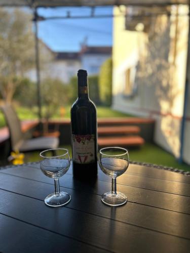 une bouteille de vin et deux verres sur une table dans l'établissement La petite Garenne - T2 Climatisé et jardin privé, à Albi