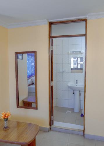 a bathroom with a shower and a sink at Durban Hotel in Dar es Salaam