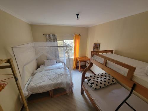 a small room with two bunk beds and a chair at EMMY'S HIDE AWAY in Iringa