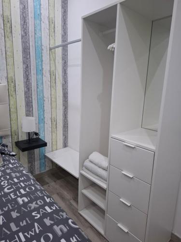 sypialnia z białą szafą z lustrem w obiekcie Apartamento PREMIUM La Biznaga w Maladze