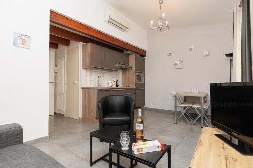 un salon avec une chaise noire et une télévision dans l'établissement Residence Aout 43, à Cannes