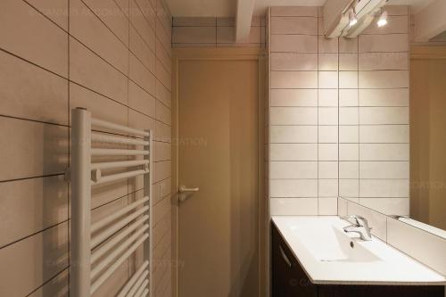 une salle de bain avec un lavabo et un miroir dans l'établissement Residence Aout 43, à Cannes