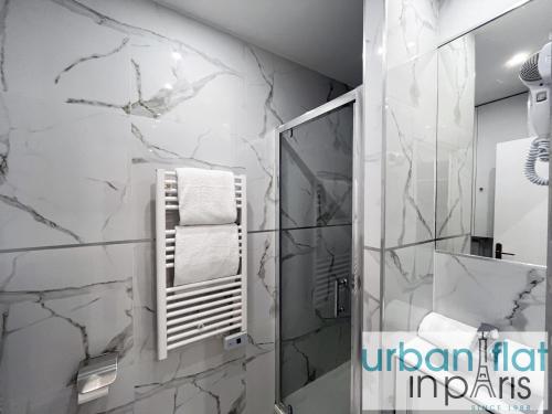 La salle de bains est pourvue d'une douche et de murs en marbre blanc. dans l'établissement 80 B - Paris Sebastopol Cinema, à Paris
