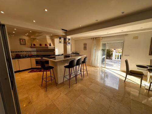 a kitchen with a bar with chairs and a table at Casa Hendrika - La Nucia Hills in La Nucía