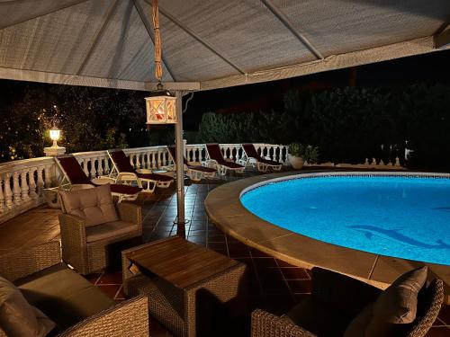 a swimming pool with chairs and an umbrella at Casa Hendrika - La Nucia Hills in La Nucía