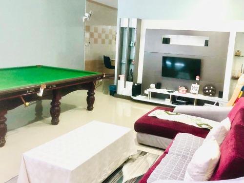 a living room with a pool table and a couch at Ang Rest House in Kuala Rompin