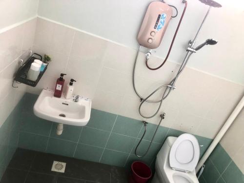 a bathroom with a shower and a sink and a toilet at Ang Rest House in Kuala Rompin