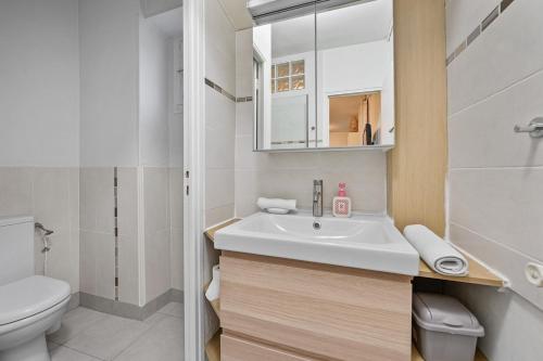 Un baño blanco con lavabo e inodoro. en Welcome to Village Parisien 1, en Saint-Maur-des-Fossés