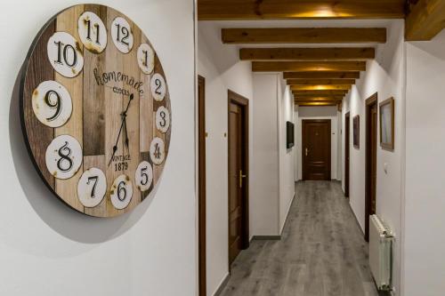 a large wooden clock on the wall of a hallway at Hotel SanMar in Cóbreces
