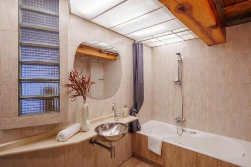 un bagno con un lavandino, una vasca e uno specchio di San Bartolome SB11 Casa con encanto bodega aire acondicionado y vistas al centro histórico by Apartamentoslogrono a Logroño