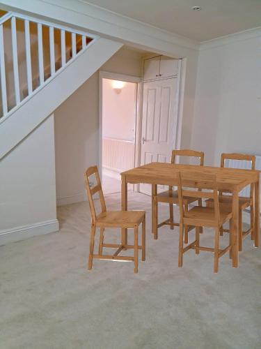 a dining room with a wooden table and chairs at The Marshmallow in Grays Thurrock