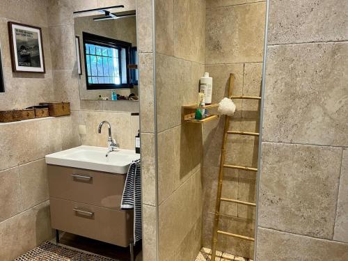 bagno con lavandino e scala accanto alla doccia di Maison avec vue imprenable a Olmeto