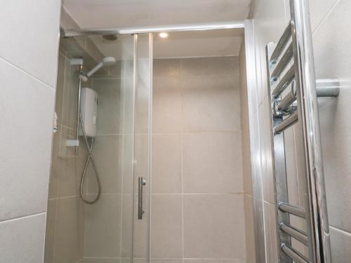 a shower with a glass door in a bathroom at Flat 1 in Penzance
