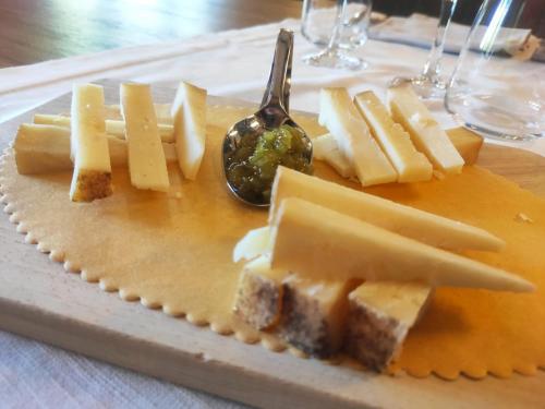 a plate of cheese on a table with a spoon at Albergo Sella - Monte Amiata in Abbadia San Salvatore
