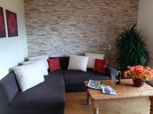 a living room with a black couch and a coffee table at Landhaus Bonaventura in Millstatt