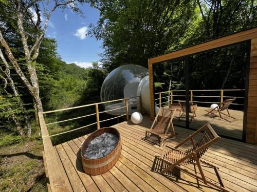 a deck with two chairs and a fire pit at Cabanes de la Romaningue in Pompignac