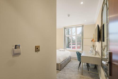 a hotel room with a bed and a desk and a window at London Star Hotel in London