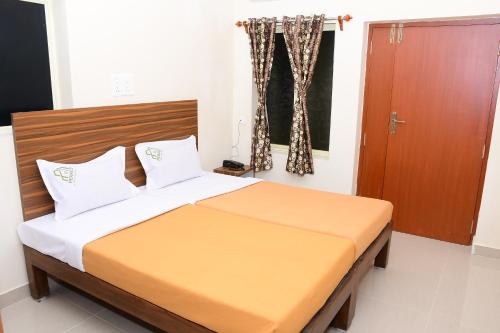 a bedroom with a bed with a wooden headboard at Perfect Residency in Mayiladuthurai