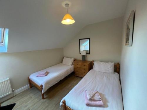 a bedroom with two beds and a mirror at Nellie's Village Stay in Beaufort