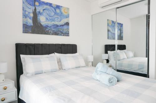 a bedroom with a large bed with a mirror at Skyline Retreat in Olympic Park in Sydney