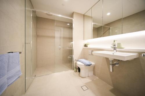 a bathroom with a toilet and a sink and a shower at Skyline Retreat in Olympic Park in Sydney