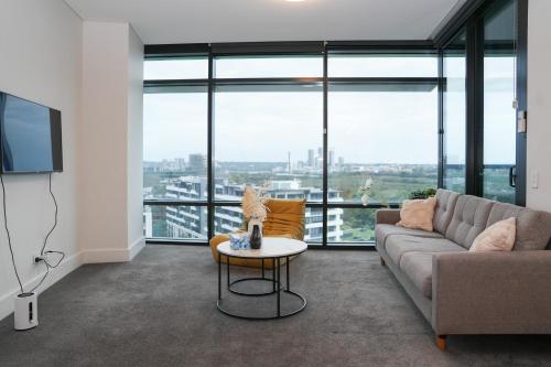a living room with a couch and a table at Skyline Retreat in Olympic Park in Sydney