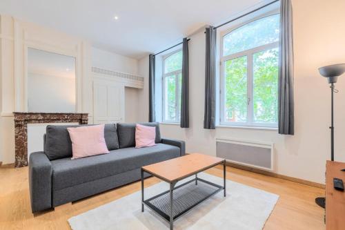 un salon avec un canapé et une table dans l'établissement Lille Centre - Appartement Lumineux !, à Lille