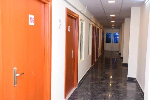 an empty hallway of an office building with orange doors at Perfect Residency in Mayiladuthurai