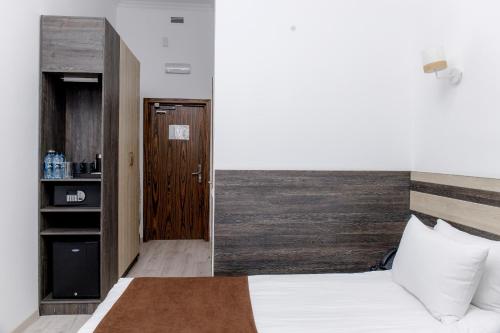 a bedroom with a bed and a wooden door at Infinity Plaza Hotel in Atyraū