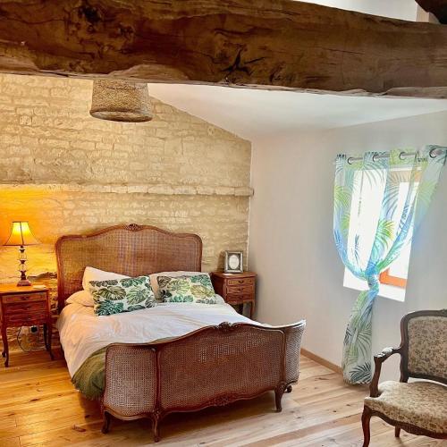 une chambre avec un lit et une chaise dans l'établissement Greengates Rose Cottage Beautiful rural French home Hot tub Heated pool, à Chives