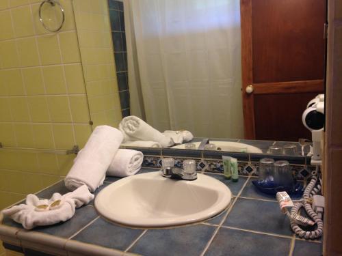 a bathroom counter with a sink and a mirror at Samara Beach Hotel in Sámara