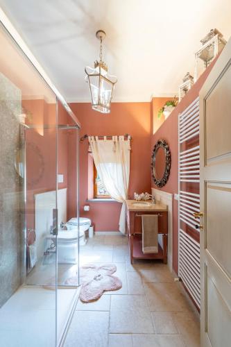 a bathroom with orange walls and a glass shower stall at Lajatico Rentals -Grotticella House, SPA Apartment in Peccioli in Peccioli