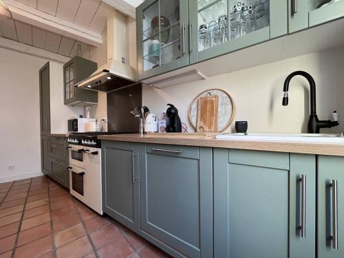 une cuisine avec des armoires bleues et un comptoir dans l'établissement Maison 4 pièces 6 couchages Saint Denis d'Oléron SDO000-382, à Saint-Denis-dʼOléron