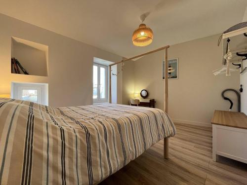 a bedroom with a bed with a striped blanket at Maison 4 pièces 6 couchages Saint Denis d'Oléron SDO000-382 in Saint-Denis-dʼOléron