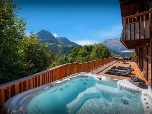 un bain à remous sur une terrasse avec des montagnes en arrière-plan dans l'établissement Chalet Morclan - OVO Network, à Manigod
