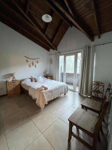 Un dormitorio con una cama grande y un techo de madera. en Casa nusa, en Esquel