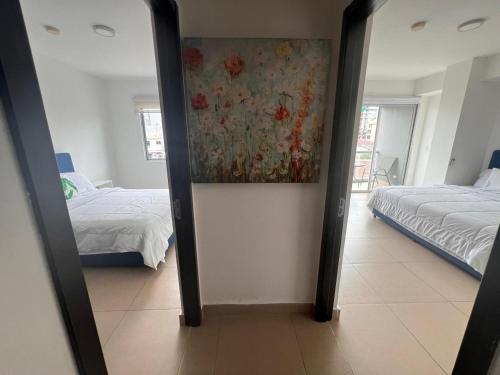 a mirror in a room with two beds and a painting at Blue Dream in San Francisco in Panama City