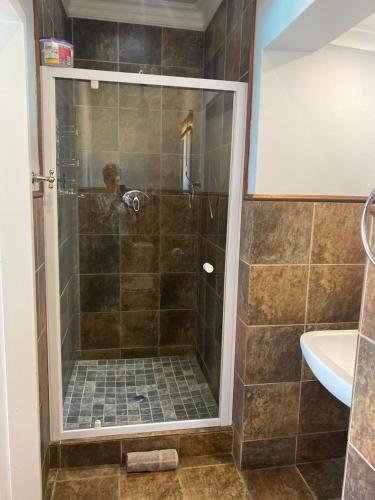 a bathroom with a shower with a glass door at Diamond Rose Guest House in Middelburg
