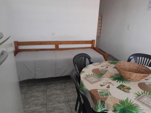 a room with a table and a bed and a table and chairs at Pensionato Nosso lar in Jandira