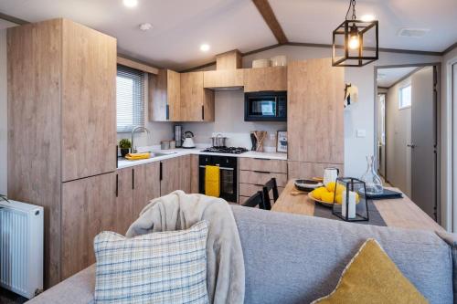 una cucina con armadi in legno e un tavolo in una stanza di Stewarts Resort Lodge 33 a St Andrews