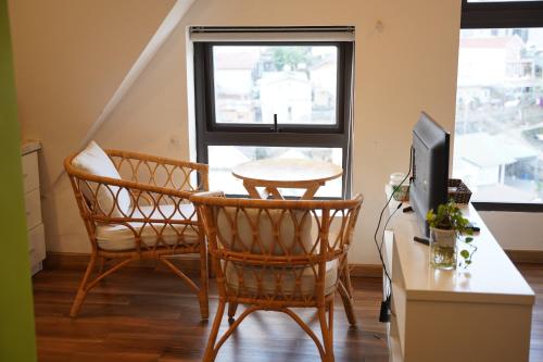 a room with a table and two chairs and a television at Love Hotel - Khách Sạn Theo Giờ in Da Lat
