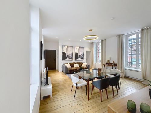 un salon avec une table, des chaises et un canapé dans l'établissement So Guest- Luxueux appartement, ancienne maison de champagne proche Cathédrale, à Reims
