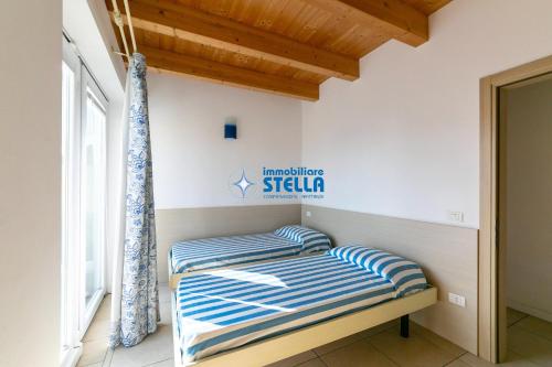 a bed with blue and white striped pillows in a room at Residence Adriatica in Lido di Jesolo