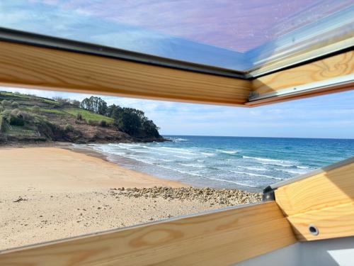 a book view of a beach from a window at Hotel SanMar in Cóbreces