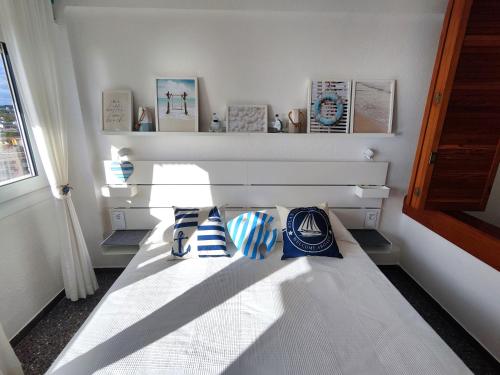 a bed with pillows on it in a room at Apartamentos con vistas al mar in Platja  d'Aro